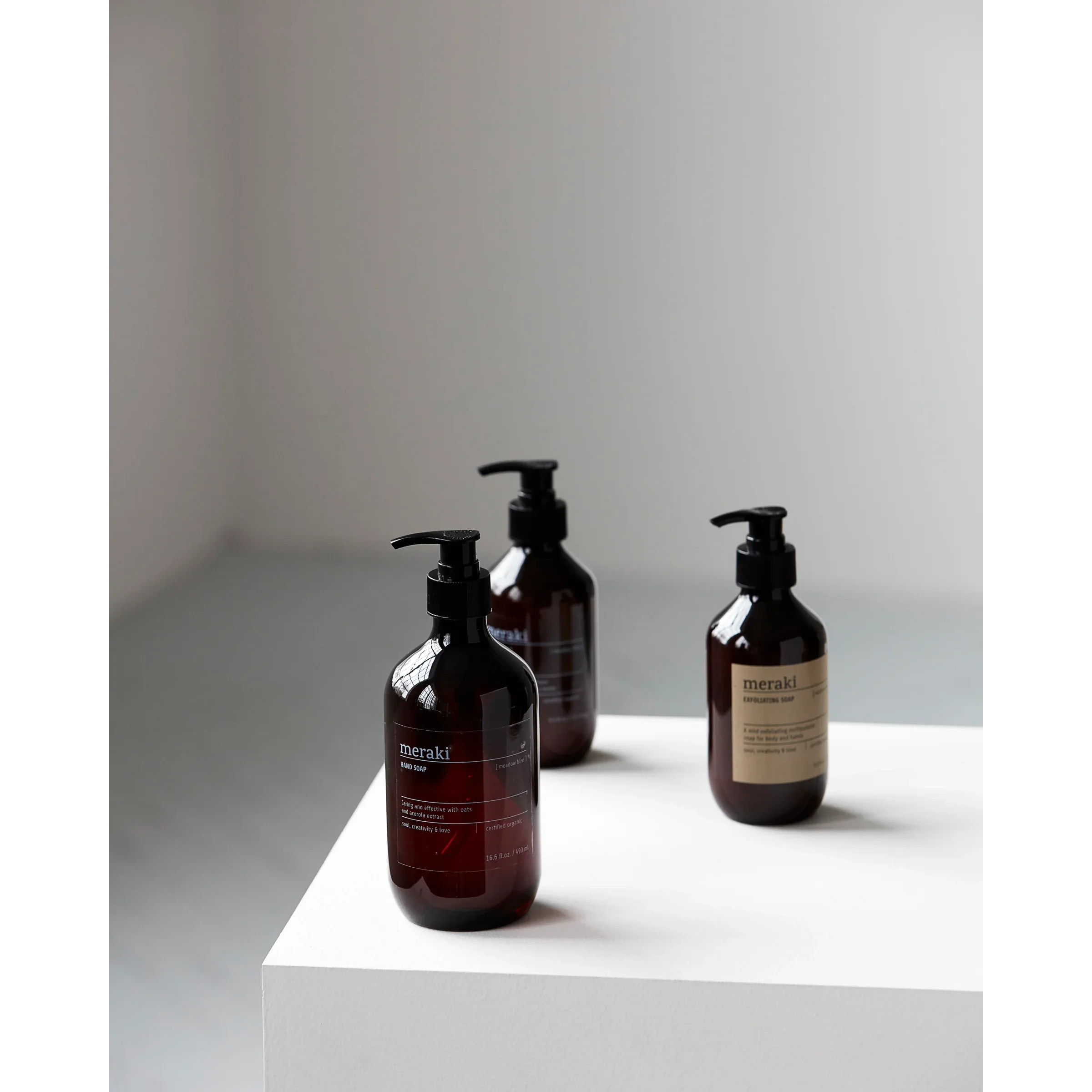 Twee Meraki Meadow Bliss handzepen op witte ondergrond, minimalistische en natuurlijke setting