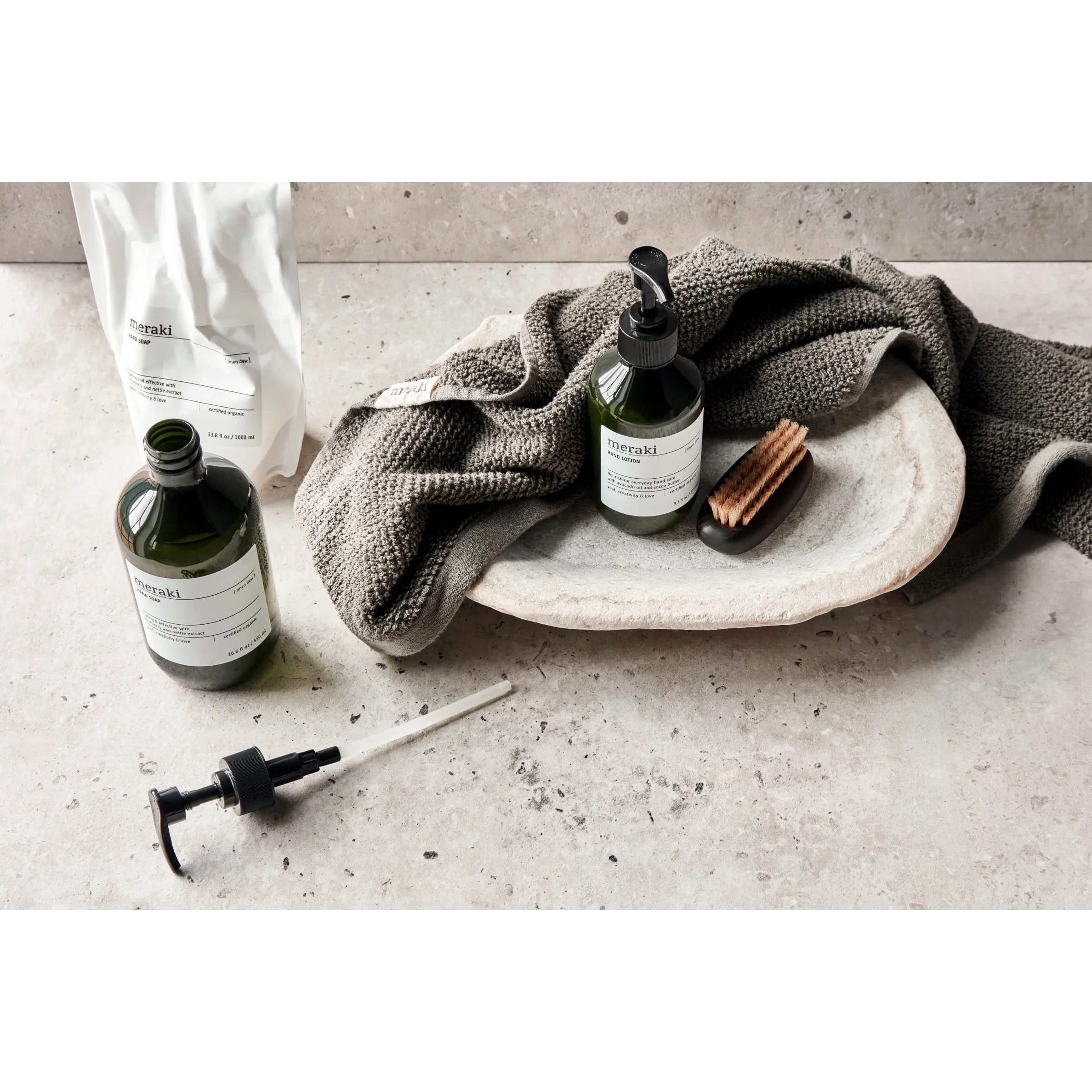 Meraki Linen Dew handzeep gestyled met linnen handdoek en natuurlijke accessoires op een stenen oppervlak

