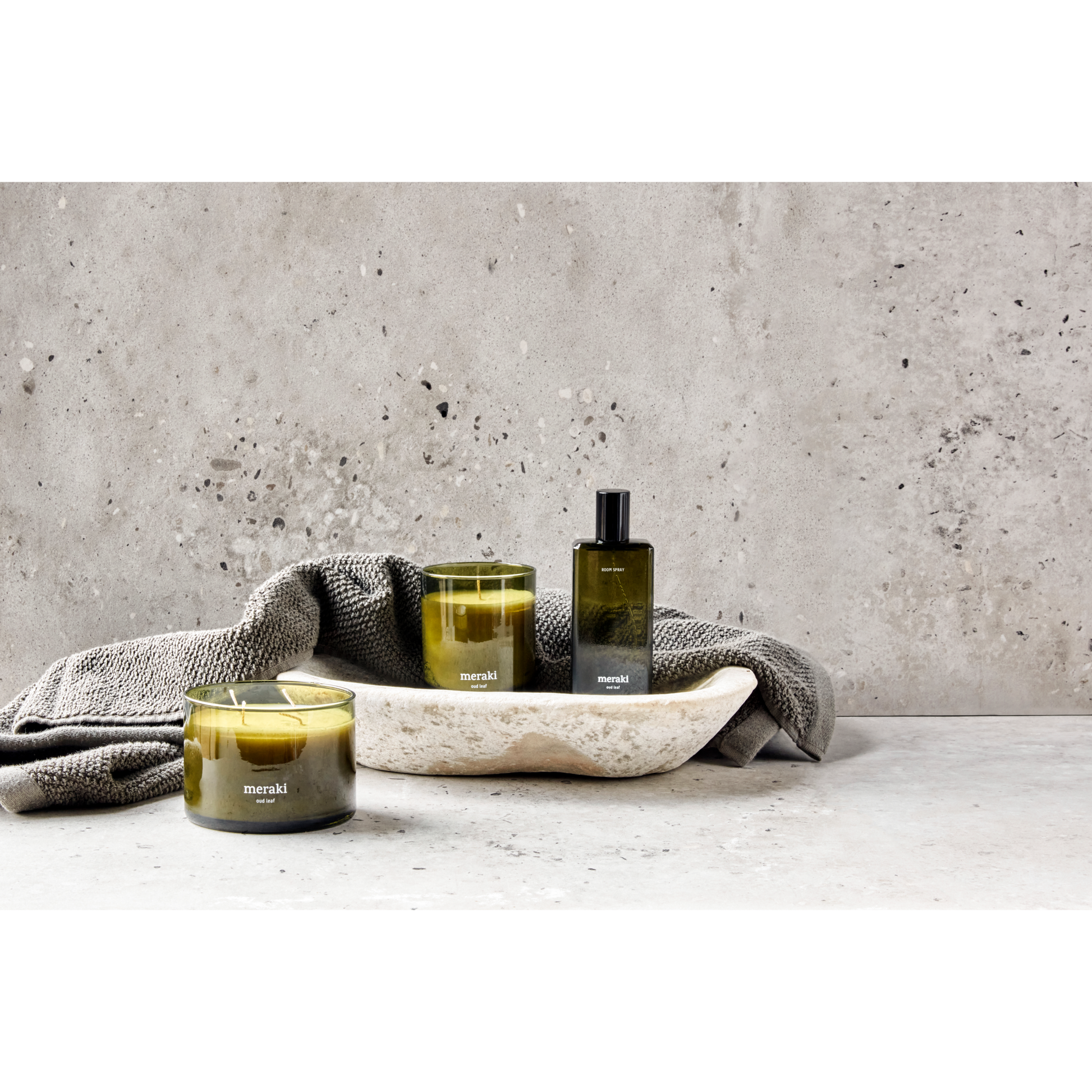 Groene Meraki geurkaars Oud Leaf met dubbele lont, gestyled op een stenen ondergrond 