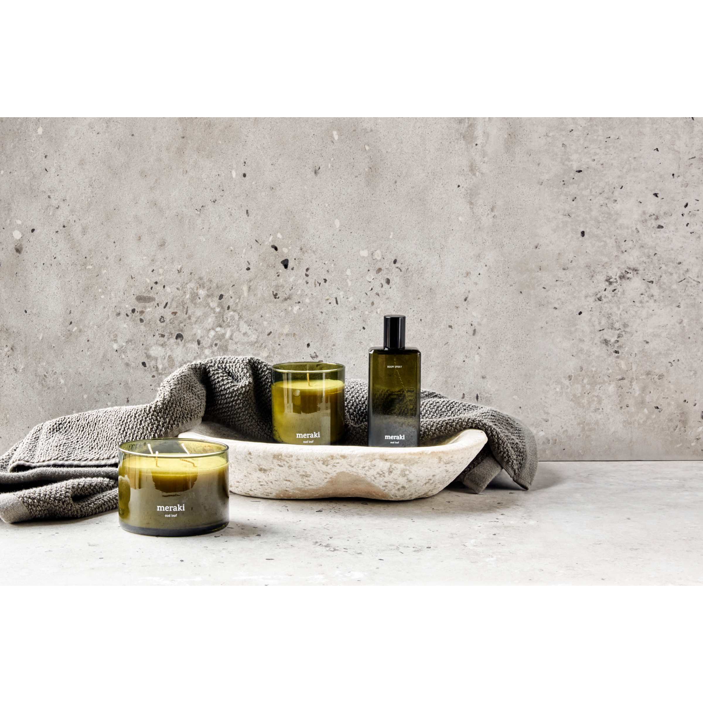 Groene Meraki geurkaars Oud Leaf met dubbele lont, gestyled op een stenen ondergrond 
